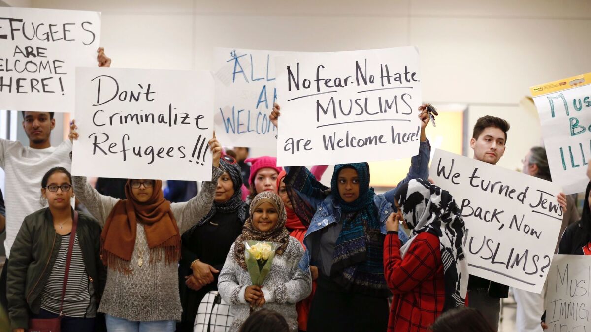 Protesters at Dallas-Forth Worth International Airport demonstrate Saturday against President Trump's executive order banning visa holders and refugees from seven countries from entering the United States.