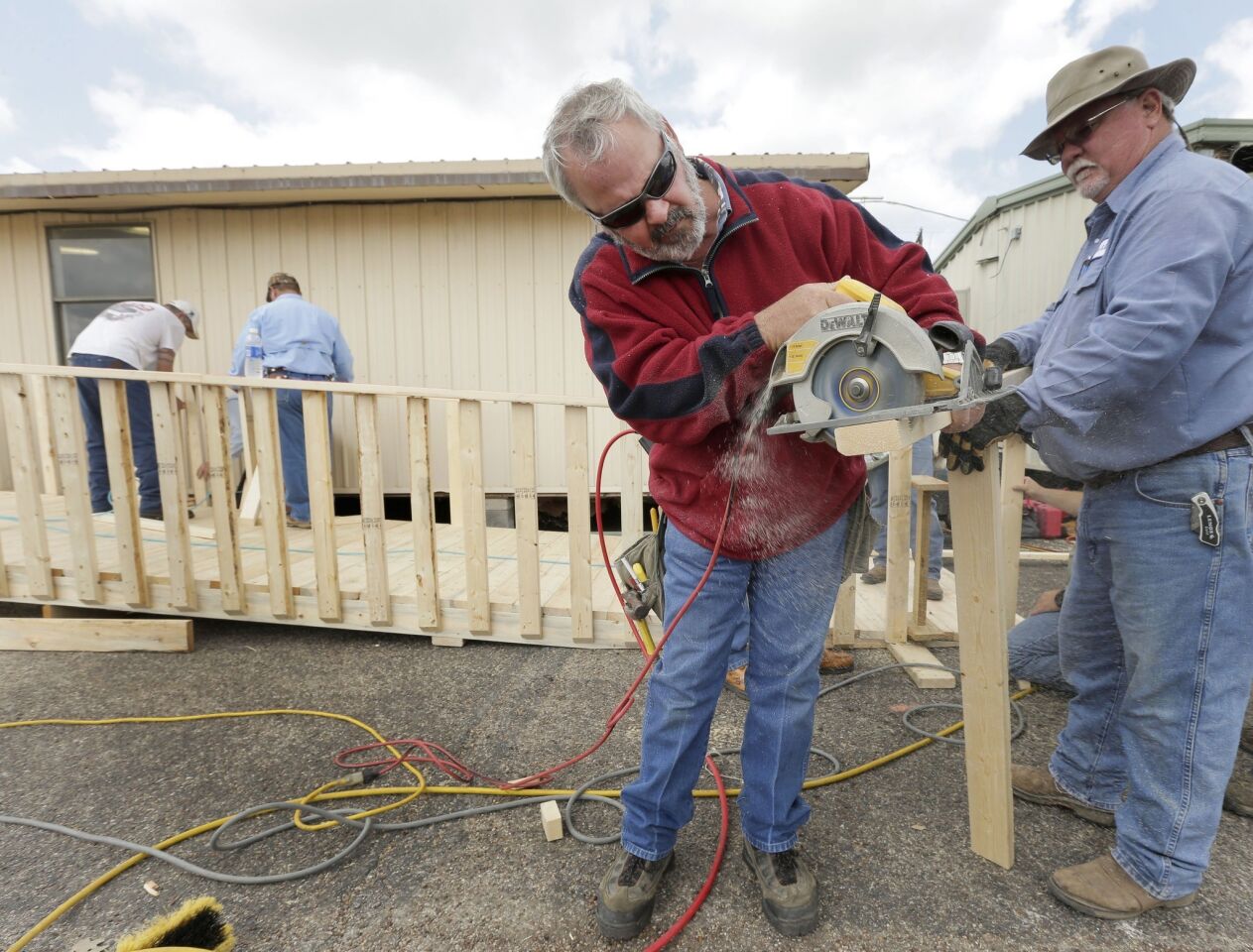 Volunteers Dub Harris and Virgil Thompson, right, both from Temple, Texas, cut lumber to build a ramp for a temporary classroom after an explosion at a fertilizer plant in West, Texas, damaged three of the district's schools.