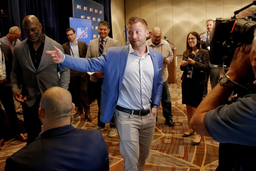 Los Angeles Rams head coach Sean McVay speaks to the media as he and Los Angeles Chargers head coach Anthony Lynn, left, view the new Los Angeles Stadium at Hollywood Park on a monitor during the annual NFL football owners meetings, Tuesday, March 26, 2019, in Phoenix. (AP Photo/Matt York)