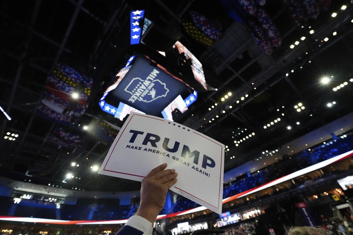 A GOP convention delegate holds up a Trump sign