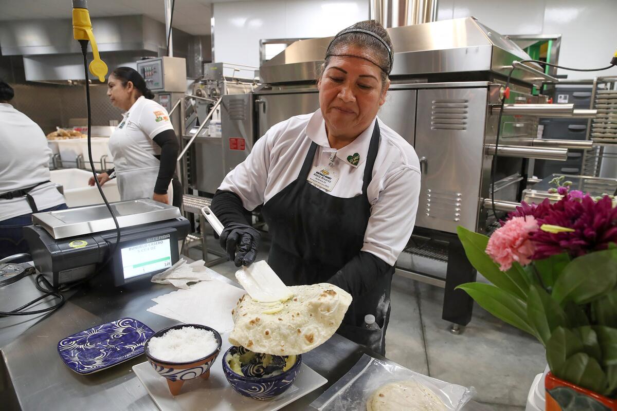 Alicia Alvarez prepares a fresh tortilla with butter and salt at Mercado González in Costa Mesa.