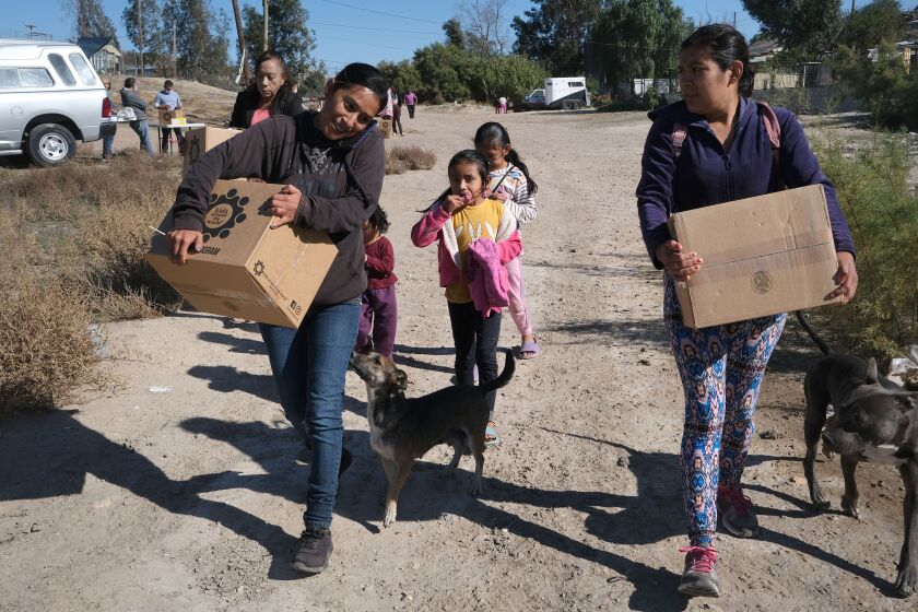 Residentes de la colonia El Niño en Tijuana reciben cajas de alimentos en noviembre de 2022. Las cajas fueron enviadas como parte del evento Million Meals de la diócesis de San Diego.