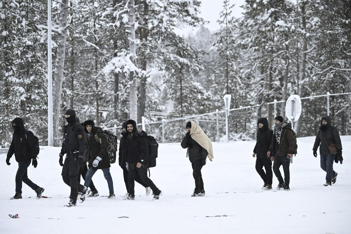 Finnish Border Guards escorting migrants