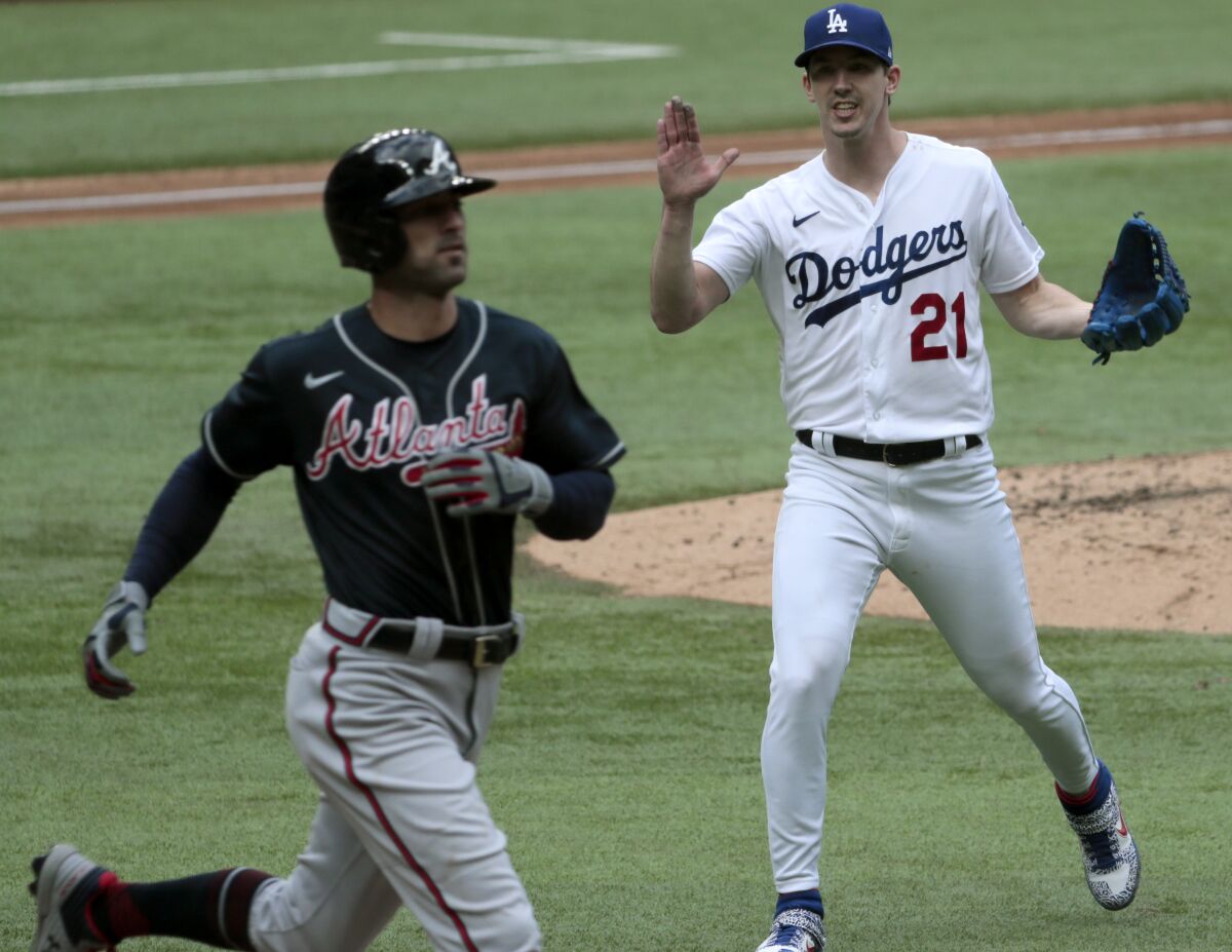 Dodgers starting pitcher Walker Buehler celebrates after throwing out Atlanta Braves left fielder Nick Markakis.