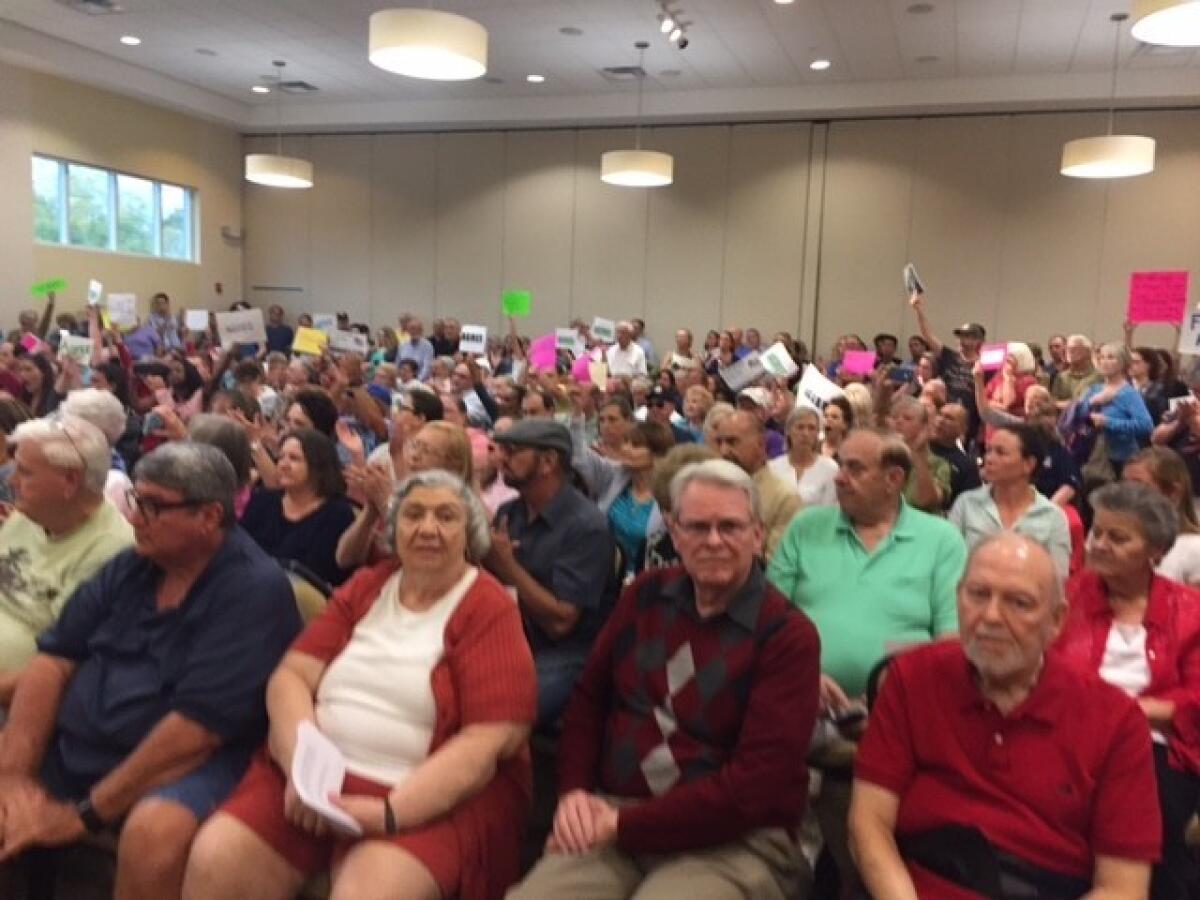 An overflow crowd awaits Dennis Ross at a town hall in Clermont, Fla.