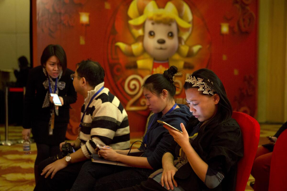 A woman browses her smartphone in Beijing on Feb. 2.