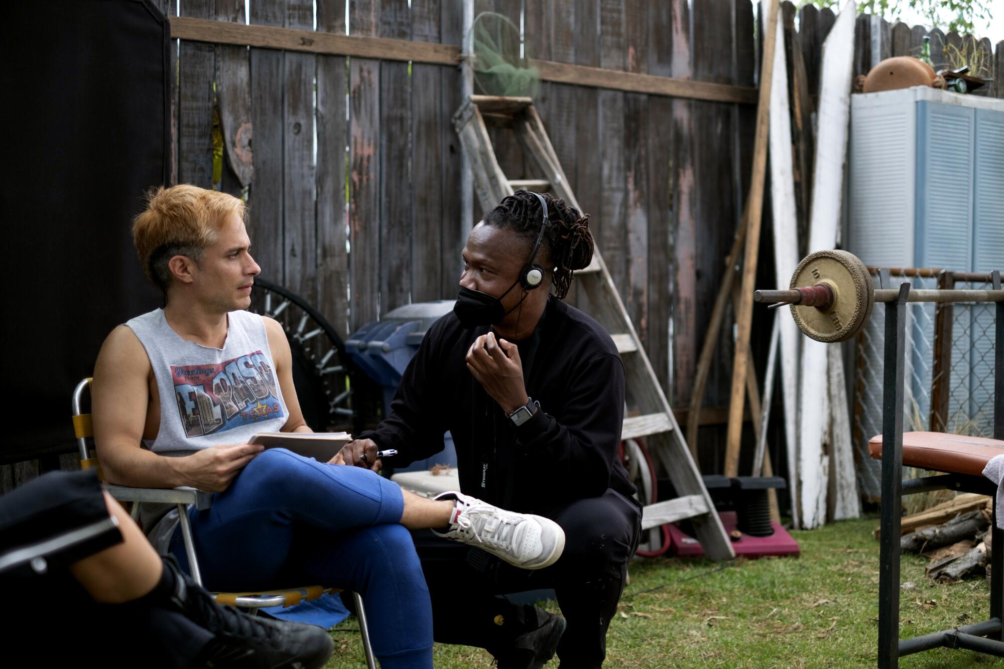 An actor and his director chat on the set of a movie.