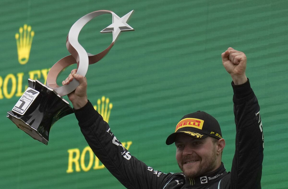 Mercedes driver Valtteri Bottas of Finland holds the trophy on the podium after winning the Turkish Formula One Grand Prix at the Intercity Istanbul Park circuit in Istanbul, Turkey, Sunday, Oct. 10, 2021. (AP Photo/Francisco Seco)