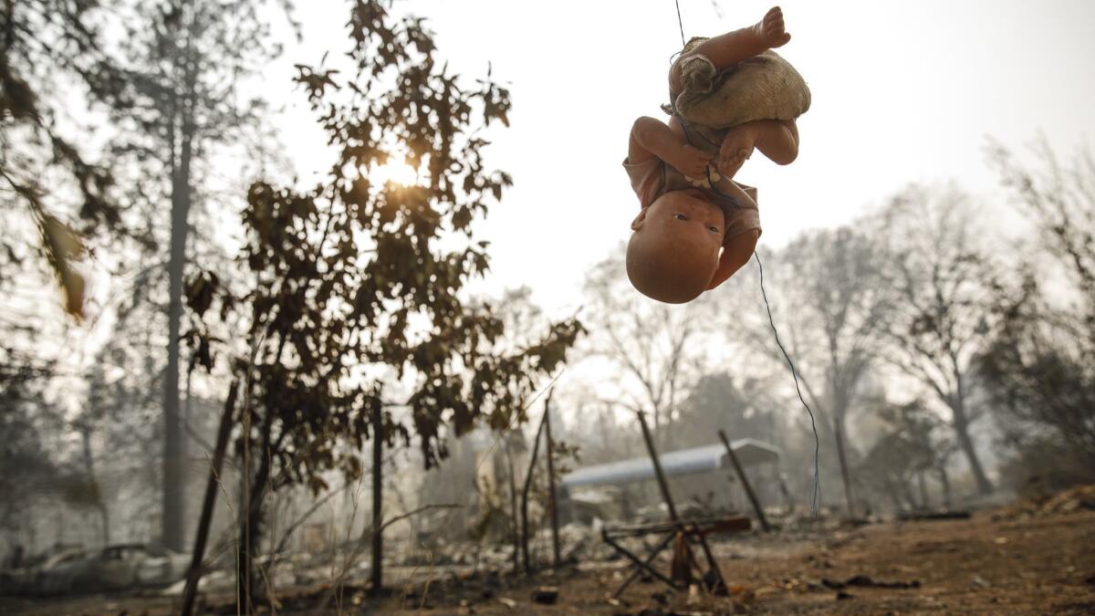 A doll hangs from a string in the backyard of a home that was burned down by the Camp Fire in Paradise, Calif.