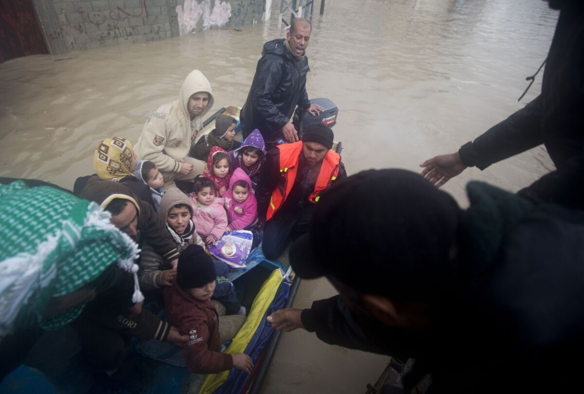 Palestinian civil defense volunteers help flooded-out residents reach safety in Gaza City on Saturday.