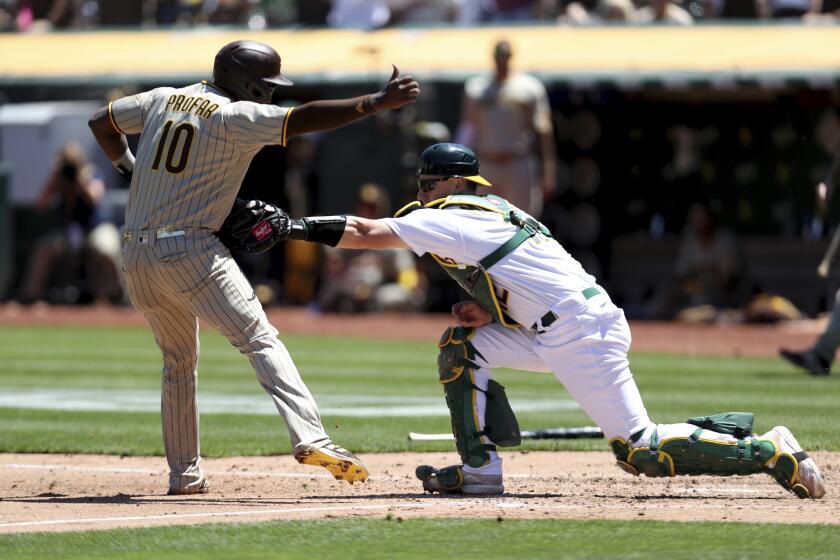 San Diego Padres' Jurickson Profar, left, is tagged out by Oakland Athletics' Sean Murphy on a double hit by Trent Grisham during the fourth inning of a baseball game in Oakland, Calif., Wednesday, Aug. 4, 2021. (AP Photo/Jed Jacobsohn)