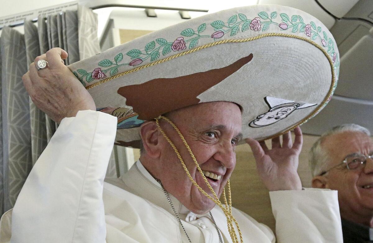 Pope Francis wears a traditional Mexican sombrero he received as a gift from a journalist aboard the plane during the flight from Rome to Havana, Cuba.