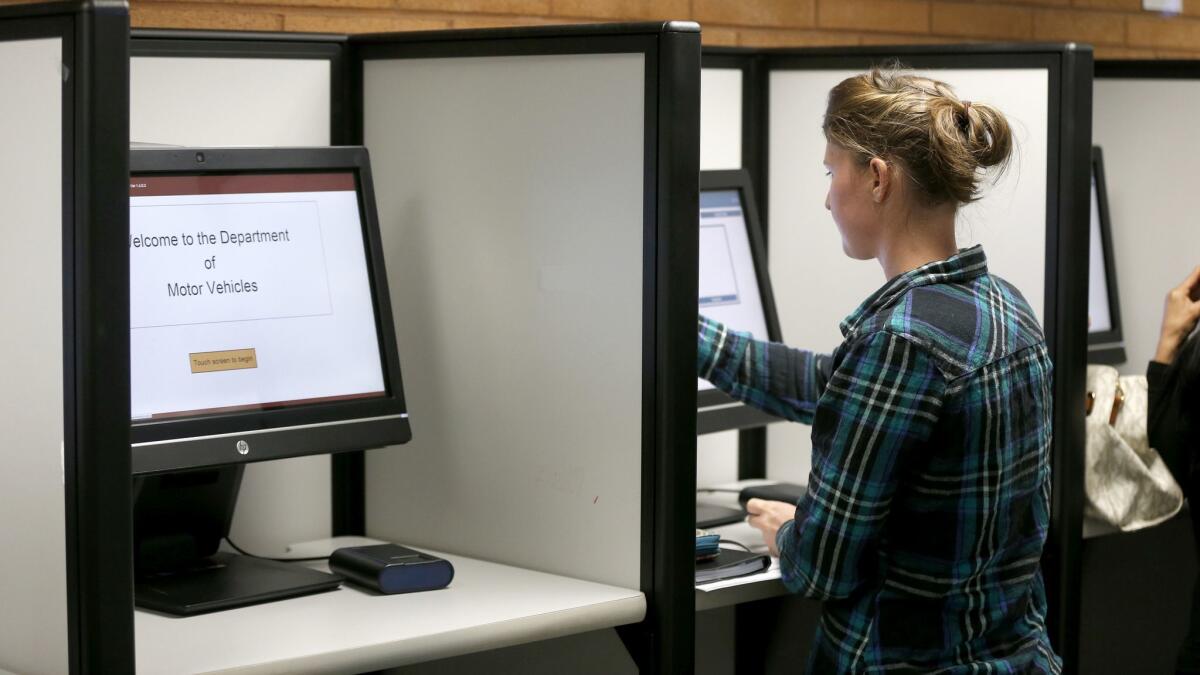 A woman registers to vote and takes her driver's test using a touchscreen machine at the Department of Motor Vehicles in Santa Ana, Calif. on May 5, 2016.
