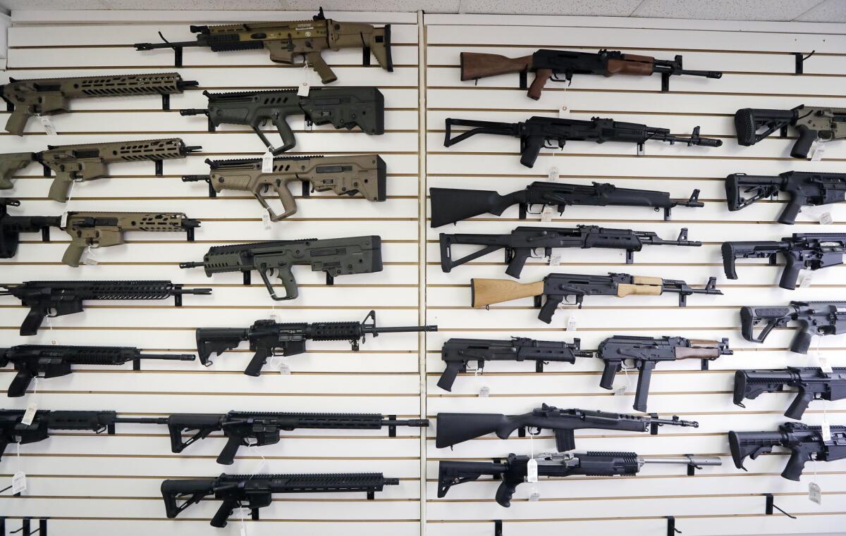 Semi-automatic rifles fill a wall at a gun shop in Lynnwood, Wash.