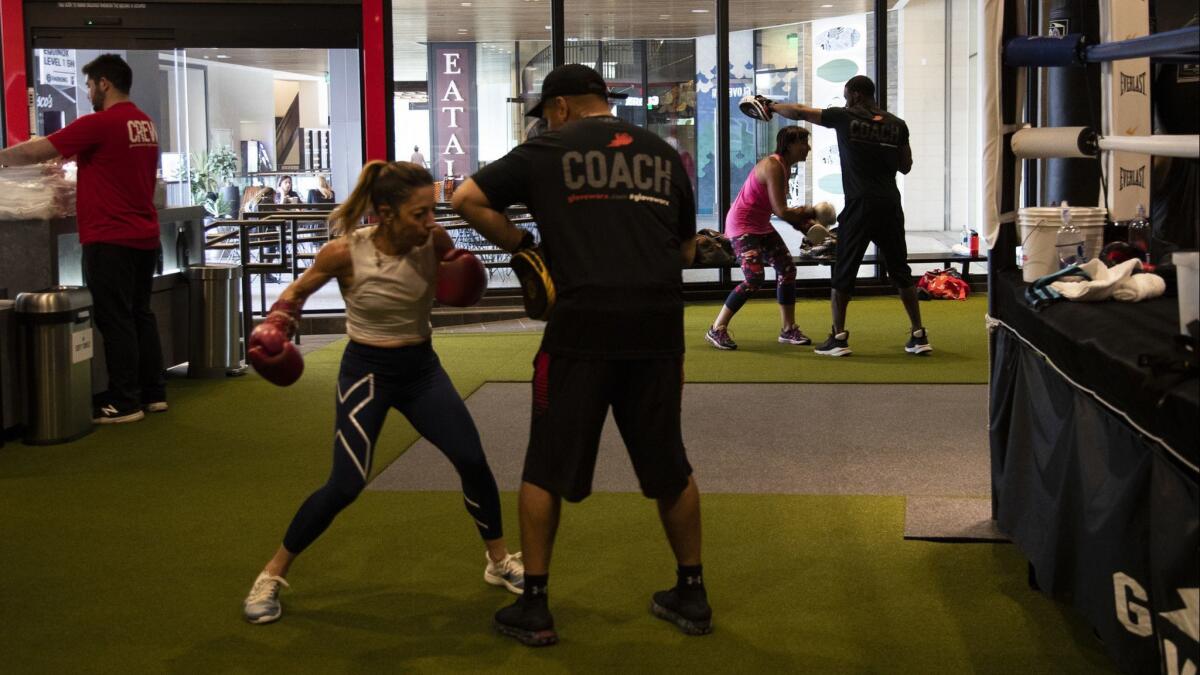 Boxing coaches work with clients at Gloveworx's new location at the Century Mall.
