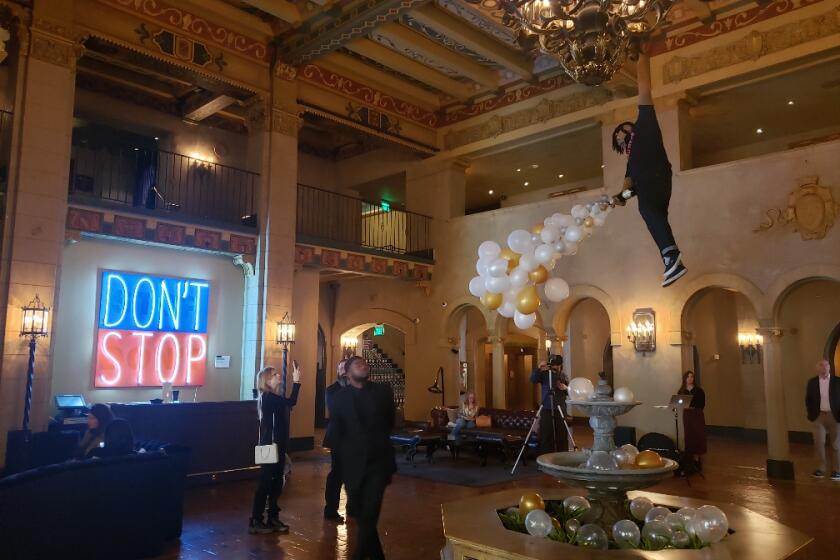 A neon sign by Deborah Kass and a chandelier/fountain sculpture by Luis Flores are in the Hollywood Roosevelt lobby