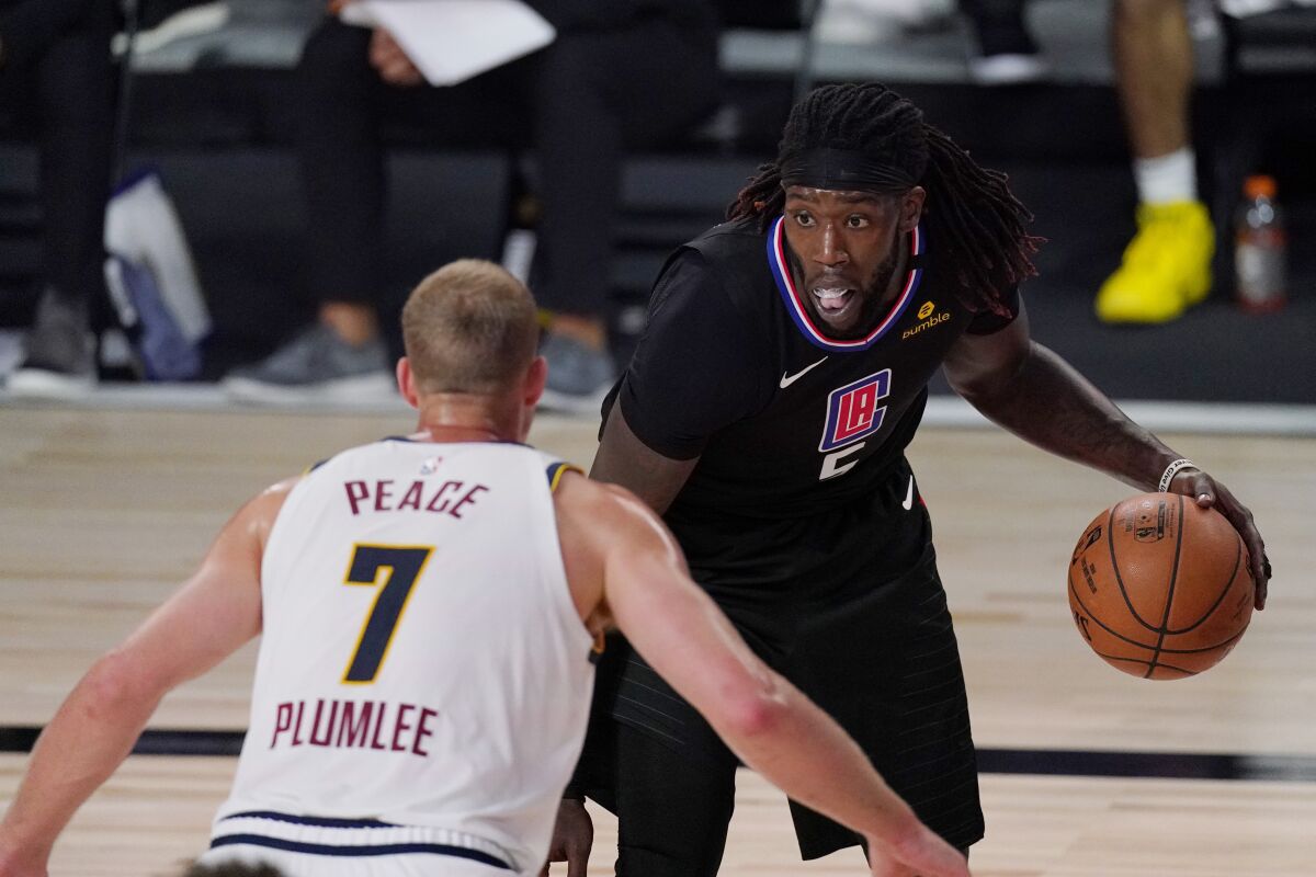 Los Angeles Clippers' Montrezl Harrell (5) is defended by Denver Nuggets' Mason Plumlee (7) in the second half of an NBA conference semifinal playoff basketball game Thursday, Sept 3, 2020, in Lake Buena Vista Fla. (AP Photo/Mark J. Terrill)