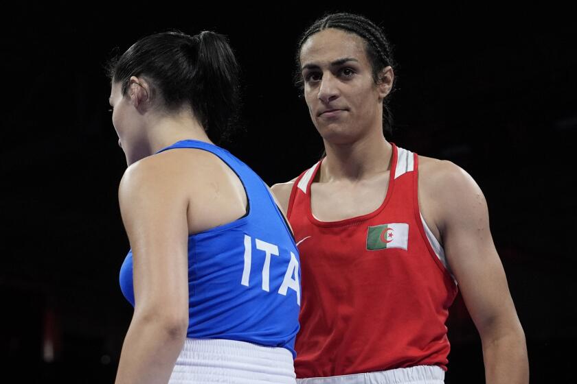 Algeria's Imane Khelif, right, walks beside Italy's Angela Carini after their women's 66kg.