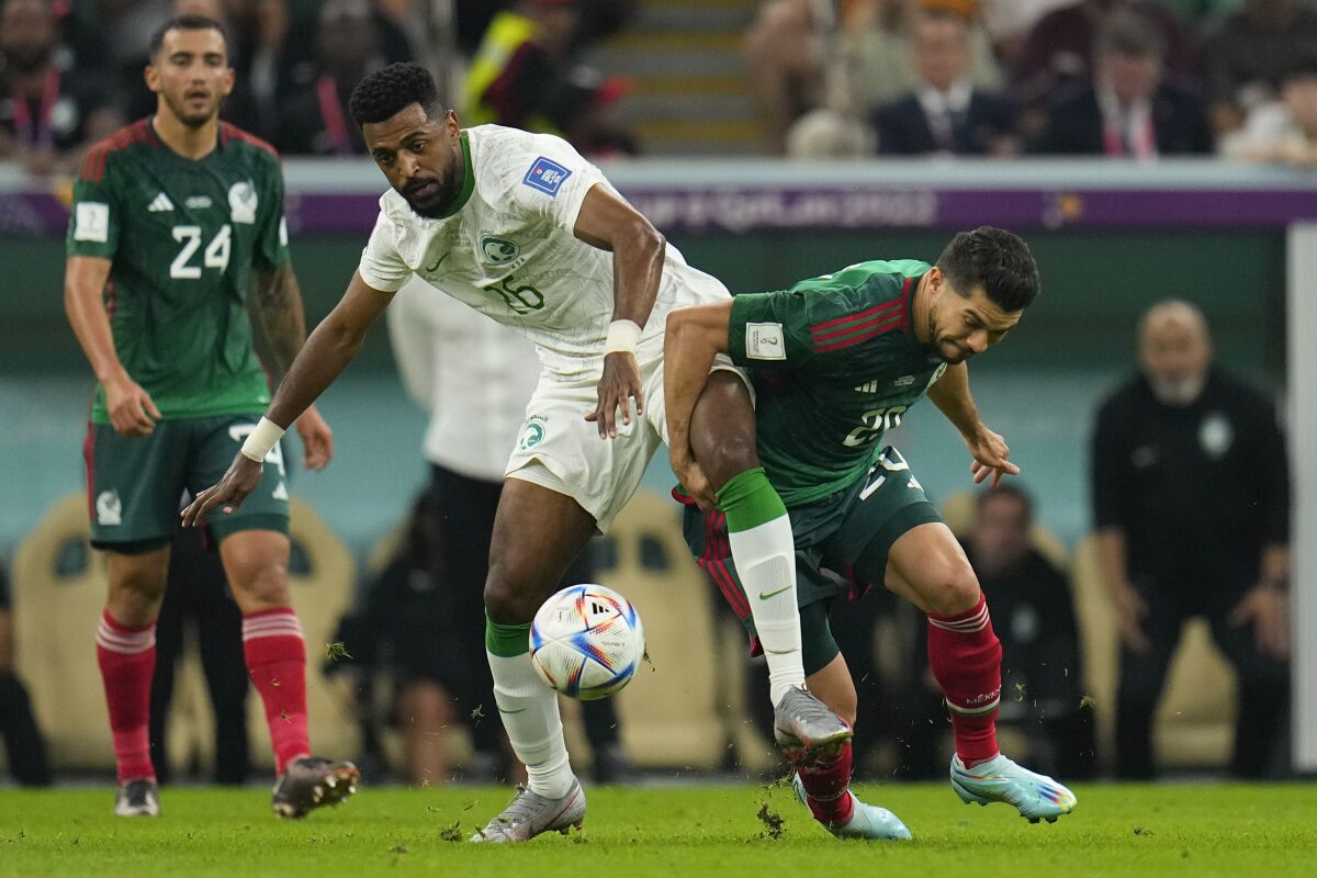Saudi Arabia's Riyadh Sharahili, center left, and Mexico's Henry Martin vie for the ball.