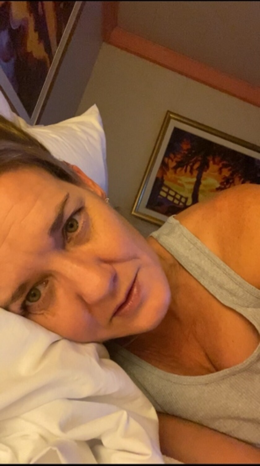 A selfie of a woman lying with her head on a pillow.