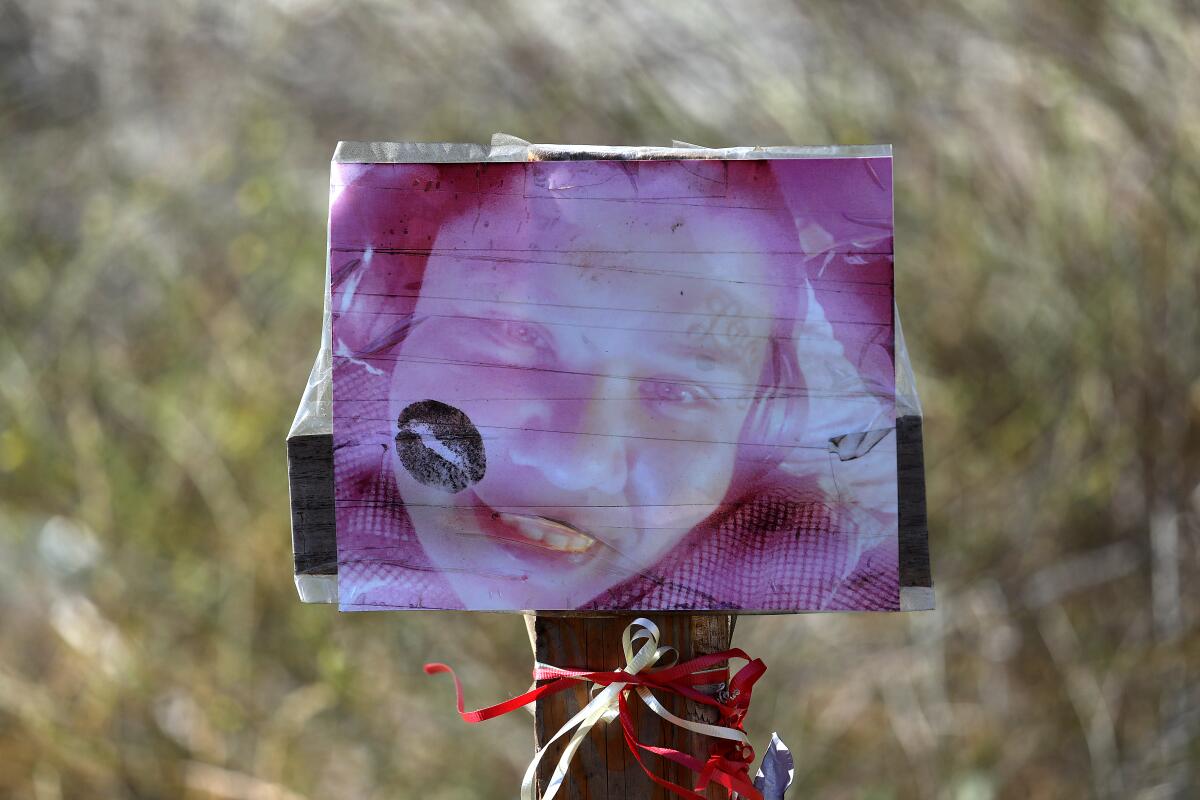 A faded photo attached to a stick at a memorial where the body of Patricia Loeza, a homeless woman, was found in Compton