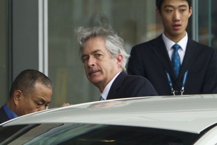 ARCHIVO - El director de la CIA, William Burns, centro, sube a un auto al arribar al Aeropuerto Internacional de la Capital, Beijing, 1 de mayo de 2012. (AP Foto/Alexander F. Yuan, File)