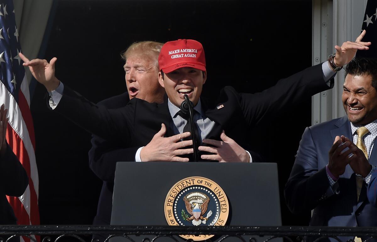 President Trump reacts as Kurt Suzuki wears a "Make America Great Again" baseball hat during a ceremony honoring the Washington Nationals on the South Lawn of the White House.