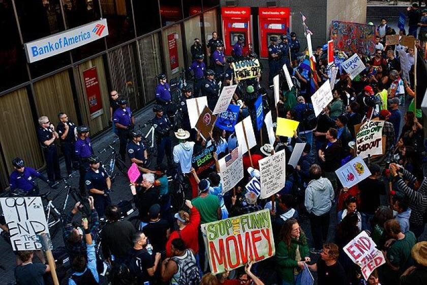 Hundreds of protesters associated with Bank Transfer Day face off with police officers guarding a Bank of America branch at the corner of 1st and Spring streets in downtown Los Angeles. Protesters were advised to take their money out of big banks and invest in smaller banks or credit unions instead. Related: Protesters march through downtown L.A.'s financial district Full coverage: Occupy protests