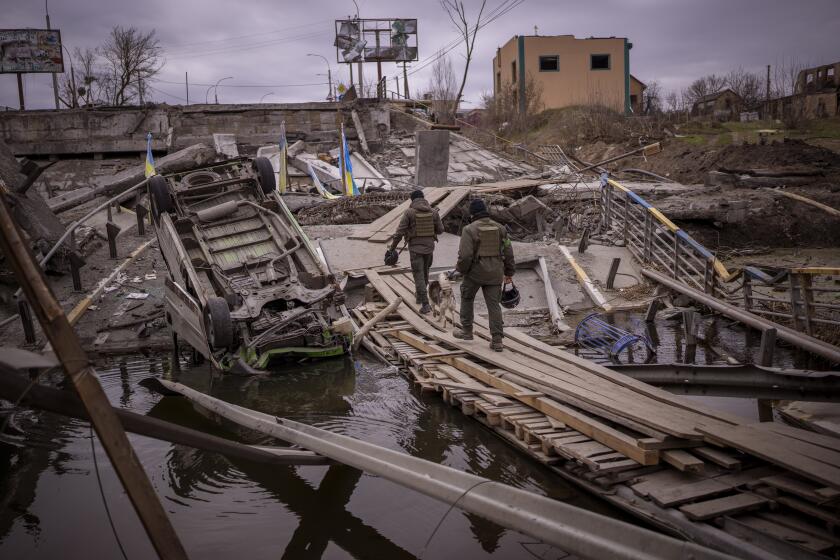 Ukrainian soldiers walk on a destroyed bridge in Irpin, on the outskirts of Kyiv, on Wednesday, April 20, 2022. (AP Photo/Emilio Morenatti)