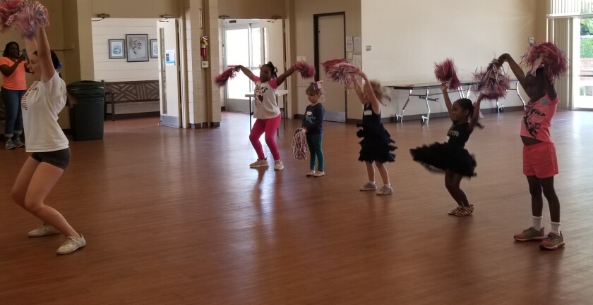 Alexandra Hill cheers with four of her students at the North Seal Beach Community Center as part of an 8-week cheerleading camp that she’s leading as part of her Gold Award project.
