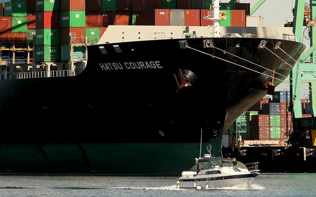 Pleasure boaters cruise past ships berthed at the Port of Los Angeles in San Pedro on Thursday.