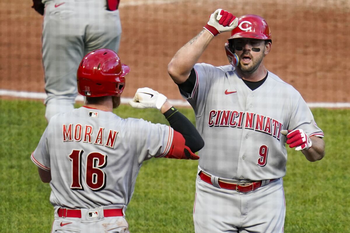 Cincinnati Reds' Mike Moustakas (9) celebrates with Colin Moran (16) after hitting a solo home run against the Pittsburgh Pirates during the third inning of a baseball game, Friday, May 13, 2022, in Pittsburgh. (AP Photo/Keith Srakocic)