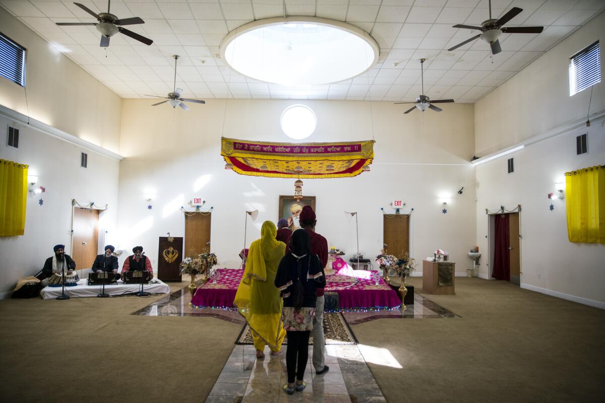 The prayer room at the Sikh Centre in Anderson, Calif. Displayed in the temple’s sunlit entryway is a green sign: “No Room for Racism.”