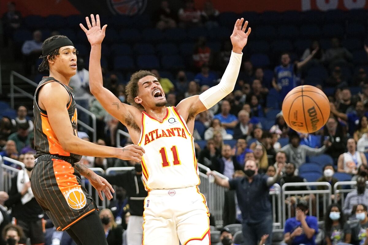 Atlanta Hawks guard Trae Young (11) reacts as Orlando Magic guard R.J. Hampton, left, knocks the ball from his hands during the first half of an NBA basketball game, Wednesday, Dec. 15, 2021, in Orlando, Fla. (AP Photo/John Raoux)