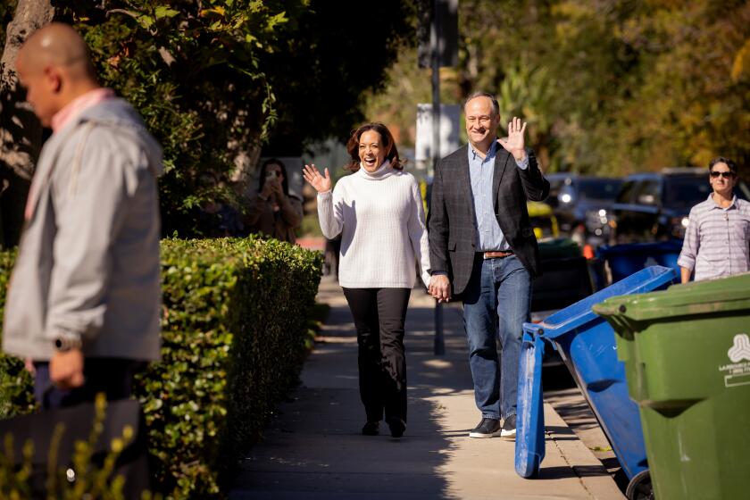 LOS ANGELES-CA- NOVEMBER 21, 2023: Vice President Kamala Harris, left, and Second Gentleman Douglas Emhoff walk through their neighborhood in Los Angeles on November 21, 2023. HOLD FOR STORY BY COURTNEY SUBRAMANIAN. (Christina House / Los Angeles Times)