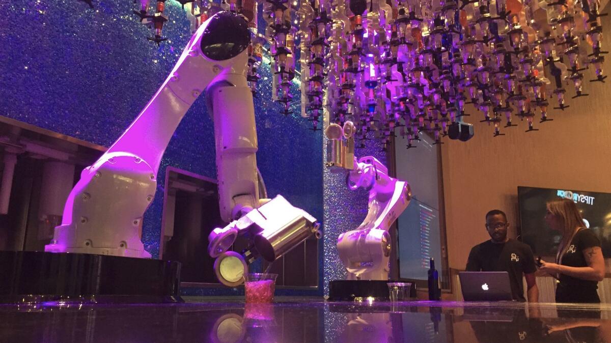 Robots sirven bebidas en el Tipsy Robot, que inauguró este verano dentro de las tiendas de Miracle Mile, junto al Planet Hollywood Casino en Las Vegas (David Montero / Los Angeles Times).