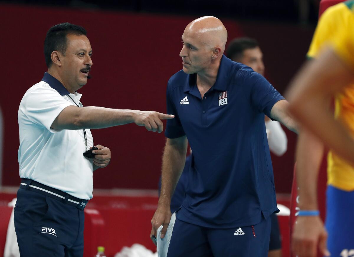 John Speraw, men's volleyball coach, talks to a referee during a game at the Tokyo Olympics.