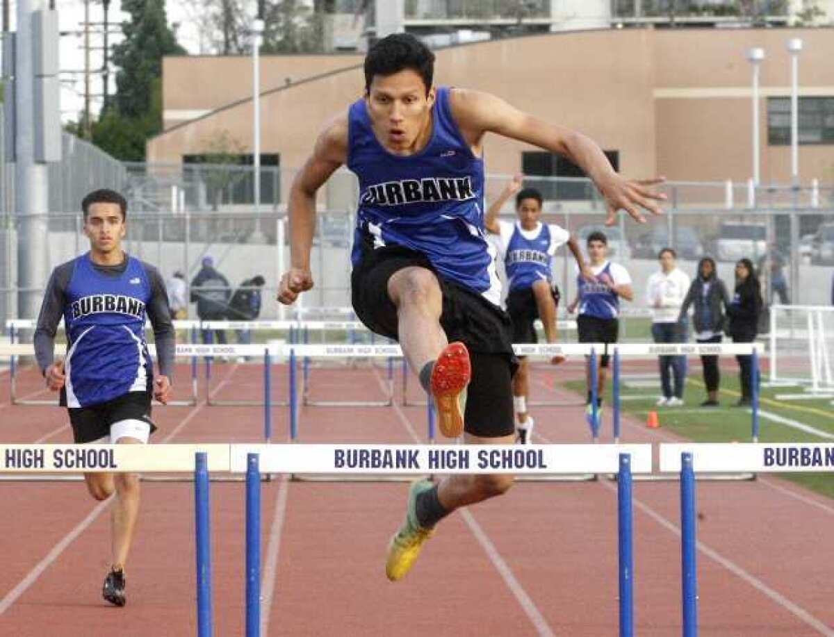 Burbank's Dennis Talacio, 17, finishes in first place in the 300 meter low hurdles against Hoover in a Pacific League dual track and field meet at Burbank High School on Thursday, March 7, 2013. Talacio won the high hurdles, and also competed in the high jump and triple jump.