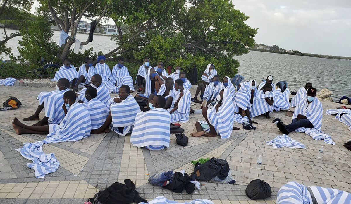 FILE - This photo provided by the United States Border Patrol shows Haitian migrants on shore wrapped in towels after a boat ran aground in the Florida Keys off Key Largo on Sunday, March 6, 2022. Haitian migrants are reaching Florida's shores in a string of suspected smuggling operations that could outpace last year's migration waves. (United States Border Patrol via AP, File)