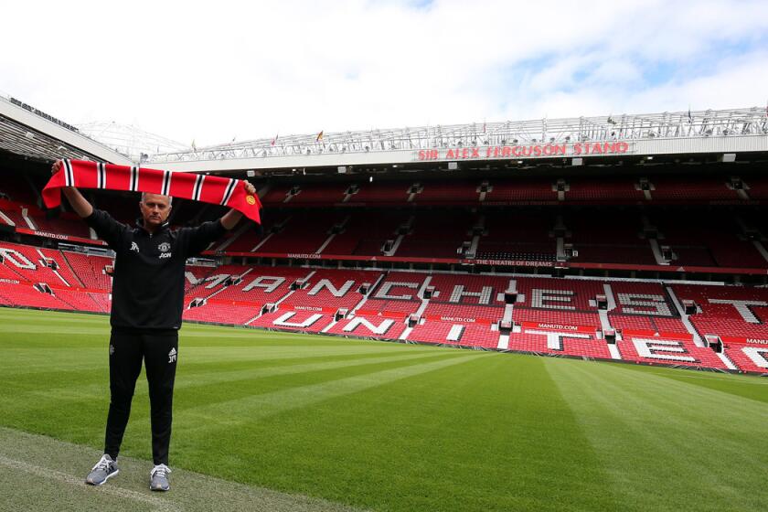 Manchester United's new manager, Jose Mourinho, poses for pictures at Old Trafford Stadium in Manchester, England, on July 5.