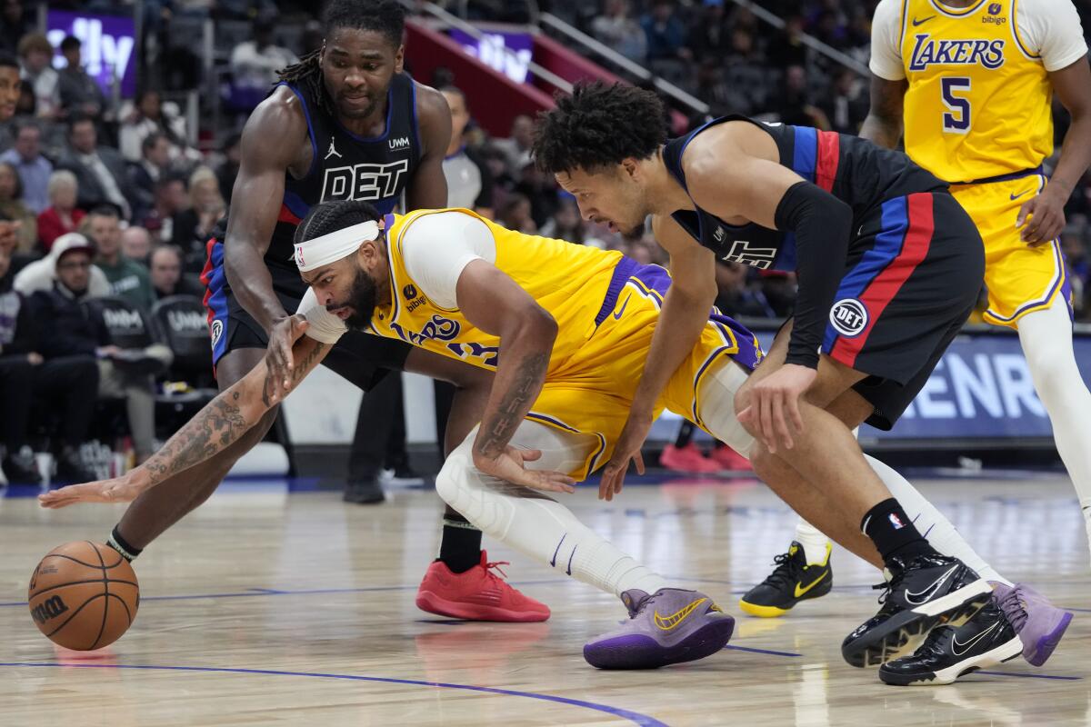 Pistons guard Cade Cunningham and Lakers forward Anthony Davis chase a loose ball on Wednesday.