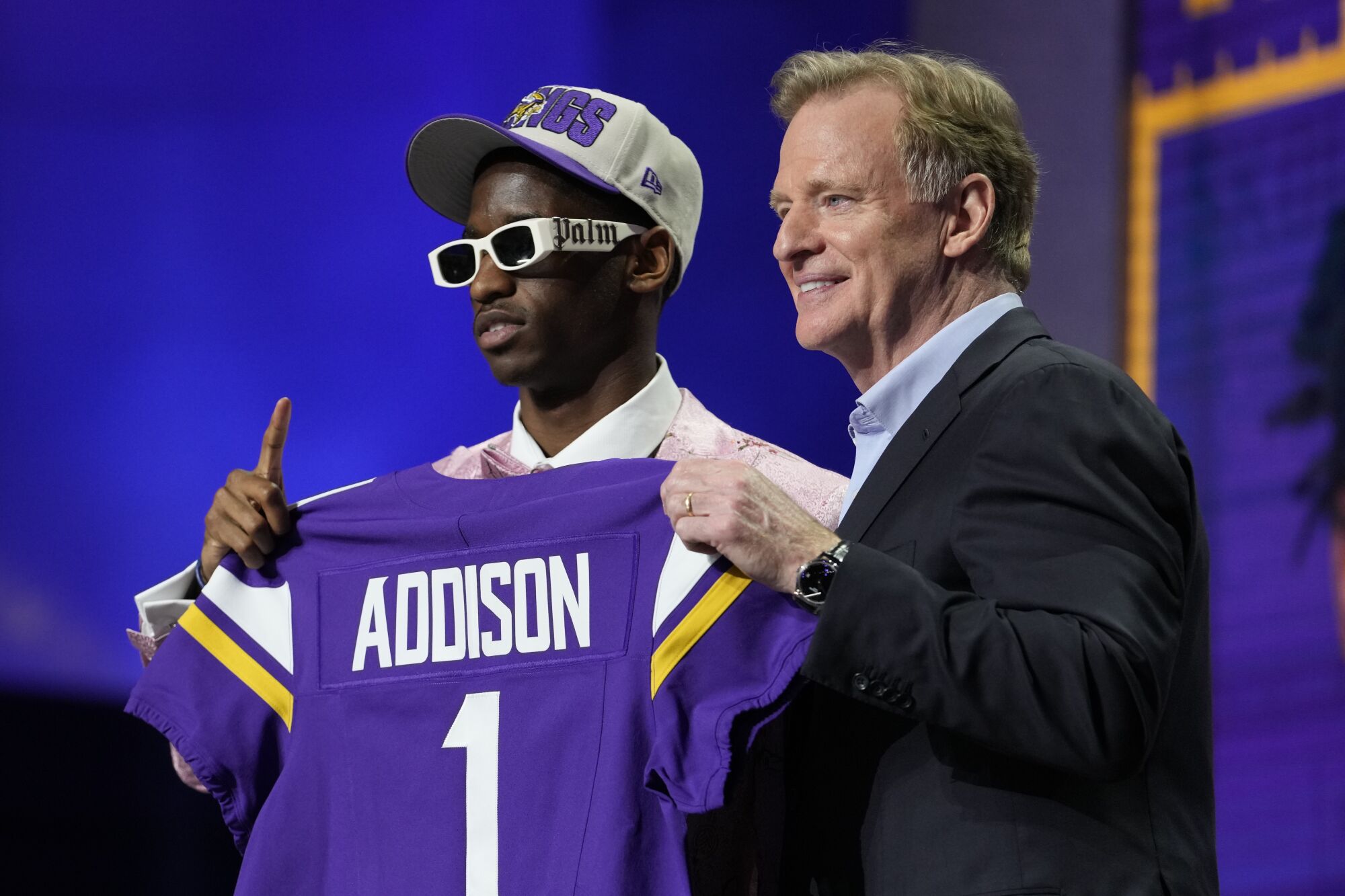 Jordan Addison and Roger Goodell hold a Vikings jersey.