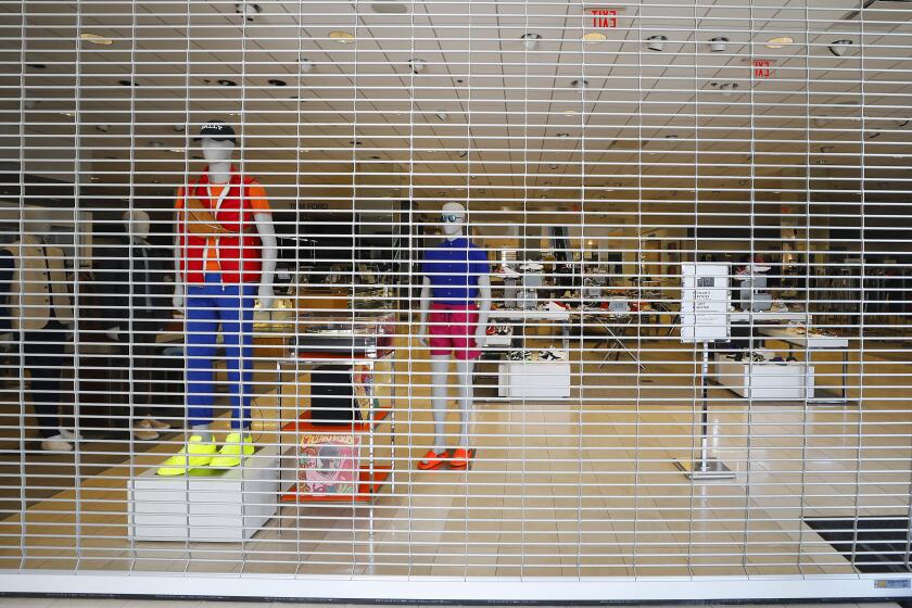 Mannequins stand behind a security gate at Neiman Marcus in Fashion Valley on April 28, 2020. Retailers have hit hard during the coronavirus pandemic. There are reports that Neiman Marcus will soon file for bankruptcy.