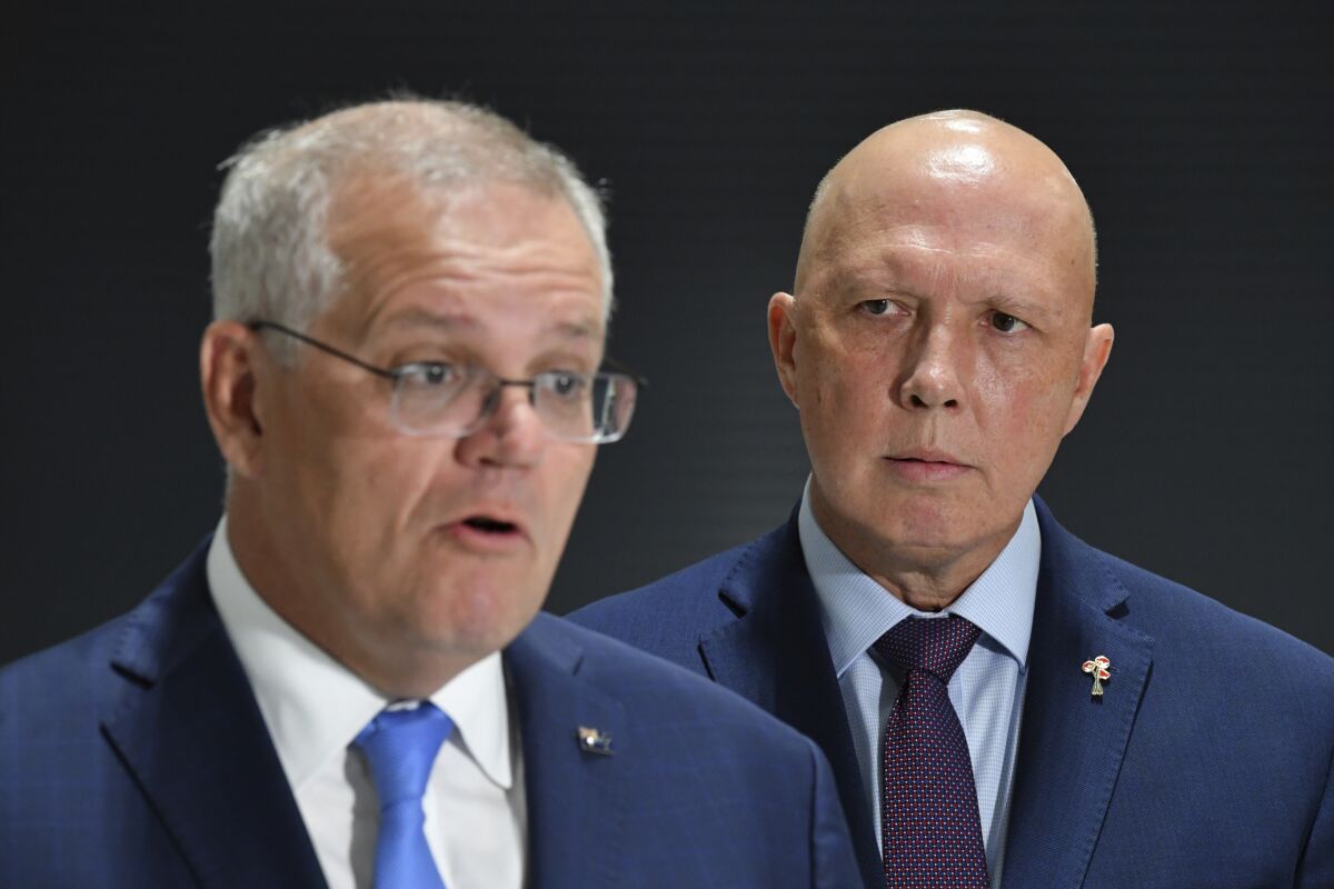 Australia Defense Minister Peter Dutton, right, watches as Prime Minster Scott Morrison speaks at a press conference after visiting TAE Aerospace near Ipswich, east of Brisbane, on April 22, 2022. Dutton said Thursday, May 5, 2022, there is evidence that the Chinese Communist Party wants Australia's government to change at the May 21 election because a center-left Labor Party administration would attempt to appease Beijing. (Mick Tsikas/AAP Image via AP)