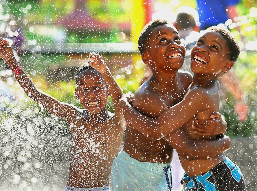 Nine-year-old William Williams, right, and his brother Xavier Robertson, 10, wait for the Big Splash machine at the Como Town water park to dump water on them in St. Paul, Minn. Temperatures hit 92 degrees in St. Paul on Wednesday, with a heat index of 97 degrees.