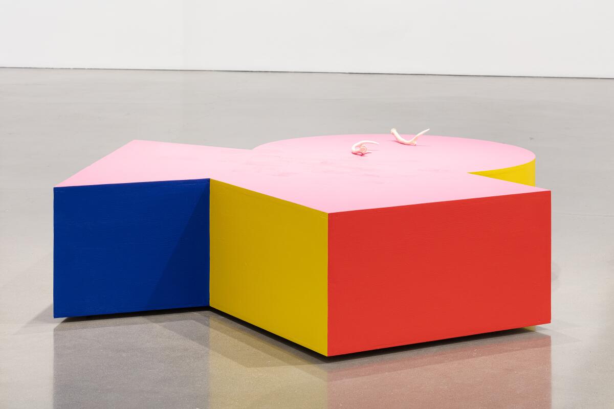 A boxy sculpture painted blue, yellow and red
