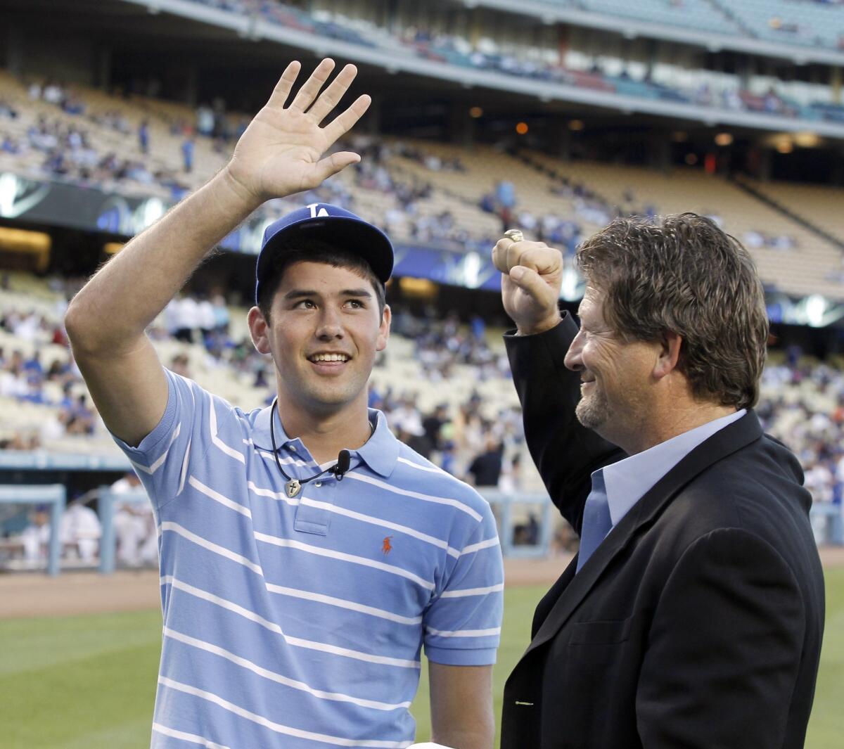 Logan White, right, introduces the team's top draft pick in 2010, Zach Lee, to the fans before a Dodgers game.