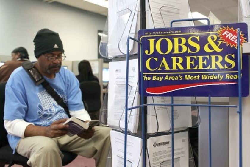 A job seeker waits to use a phone at a career center in Richmond, Calif. Economist Jack Kyser predicts that the states jobless rate will average 12.6% next year, but other economists call his prediction overly pessimistic.