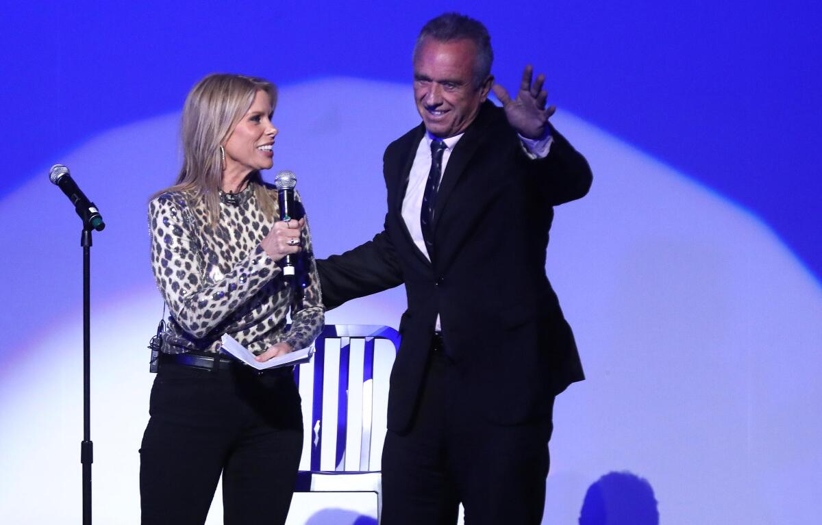  Cheryl Hines introduces husband Robert F. Kennedy Jr. on a stage.