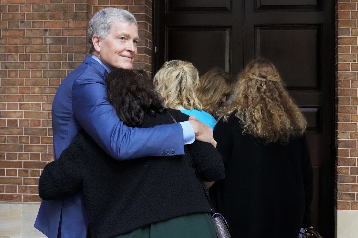 Relatives of slain man embracing outside courthouse